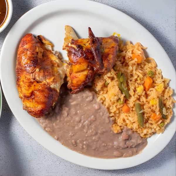 Luna's Mexican Rotisserie chicken with rice and beans on a white plate.